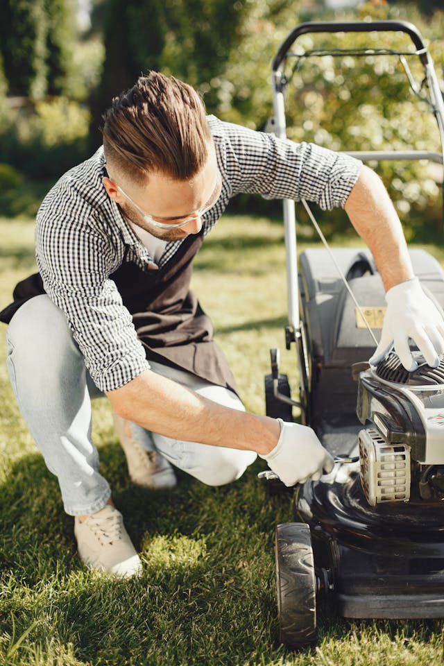Man is mowing his lawn after an auto accident.